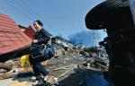 Tagajo. Mieszkaniec zniszczonej dzielnicy wydobył z ruin  swego domu szkolny plecak syna