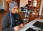 Stojący na podłodze Robotino jest sterowany myślami odczytywanymi przez elektrody umieszczone na głowie człowieka (fot. Alain Herzog/EPFL)