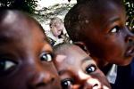 Michał Szalast,  II miejsce – Portret  – zdjęcie pojedyncze, freelancer. Zdjęcie należy do cyklu o życiu albinosów w Tanzanii. Są tam narażeni na porwania i śmierć. Ich części ciała można sprzedać, ponieważ, według afrykańskich wierzeń, mają właściwości uzdrawiające. Często jednak albinosi są chronieni przez lokalną społeczność. Dziewczynkę ze zdjęcia codziennie rano ktoś odprowadza do szkoły. Inne dzieci lgnęły do obiektywu, ona była zamknięta w sobie i osowiała. Bez przerwy coś ją swędzi. Przez brak pigmentu w skórze promienie słoneczne są dla niej zabójcze. Narażona jest na infekcje i raka. Jej życie mógłby znacznie ułatwić zwykły krem przeciwsłoneczny. Niestety, wszyscy jej bliscy są bardzo ubodzy. 