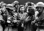Lato 1941 roku. Dziewczęta ukraińskie witają kwiatami żołnierzy niemieckich na ulicach Lwowa