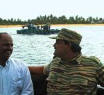 Thillaiyampalam Sivanesam „Pułkownik Soosai”, dowódca sił morskich Tamilskich Tygrysów – w tle łódź bojowa partyzantów, 2003 r. 