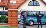 Policjanci i prokuratorzy przeszukali  dom rodziny Olewników pod Płockiem. Na zdjęciu funkcjonariusze przed posesją w 2009 r.