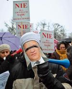 Samorządowcy protestujący przed gmachem resortu sprawiedliwości założyli maski przedstawiające ministra  Jarosława Gowina 