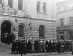 Grupa mężczyzn przed synagogą Nożyków przy ul. Twardej, gdzie zorganizowano magazyn. Prawdopodobnie czekają na pracę. Fot. Mieczysław Bil-Bilażewski 