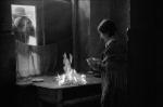 Papusza (Jowita Budnik) pali swoje wiersze. Przez okno zagląda jej mąż Dionizy Wajs (Zbigniew Waleryś)