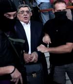 Nikolaos Michaloliakos, przywódca Złotej Jutrzenki, wyprowadzany z sądu po całonocnym przesłuchaniu