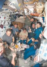 Wspólny posiłek załogi wahadłowca Columbia i astronautów na stacji orbitalnej w 2008 roku 