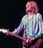 Kurt Cobain ukryty  za włosami, podczas koncertu