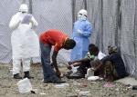 Lekarze w ubiorach ochronnych i ich pacjenci przed jednym ze szpitali w Monrowii w Liberii  