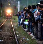 Imigranci z Azji czekają w Macedonii na pociąg, który przybliży ich do Węgier