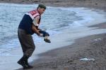 Turecki policjant podnosi ciało trzyletniego Aylana Kurdi na wybrzeżu Bodrum 