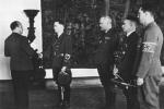 <Hitlerowcy na Wawelu. Gubernator Hans Frank (pierwszy z lewej) podejmuje Ottona von Wächtera (drugi z lewej), gubernatora dystryktu Galicja. W tle wawelskie arrasy, zrabowane przez Niemców, ale odzyskane przez Polskę