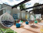 Idea Hub w Warszawie ma wewnętrzne patio,  w którym ulokowano stoliki  do pracy, kanapy, fotele, hamaki