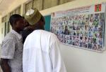 Mieszkańcy Maiduguri analizują plakat nigeryjskiej armii przedstawiający podobizny setki podejrzanych o udział  w akcjach dżihadystów Boko Haram