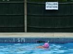 Pani Anne Whitman pływa w podgrzewanym basenie po oddaniu głosu w komisji wyborczej (w głębi) w Arundel
