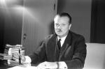 Pokerowy gracz z drzwiami ze sklejki w tle: Bolesław Piasecki w swoim gabinecie prezesa, połowa lat 60.  