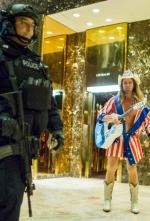 Policjant z niepokojem przygląda się występowi roznegliżowanego kowboja w lobby Trump Tower.