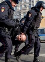 Policja niesie jednego z aresztowanych na placu Puszkina w Moskwie 