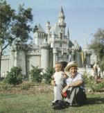 Disney ze swoim wnukiem na terenie Krainy Szczęśliwości, czyli Disneylandu. Pomimo początkowych kłopotów baśniowy park rozrywki od 1955 r. przyciąga tłumy turystów i przynosi krociowe zyski.