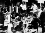 Bobby Fischer (w centrum) kontra Tigran Petrosjan, Belgrad, 30 marca 1970 roku. Jeden z wielu pojedynków amerykańskiego geniusza z plejadą wspierających się radzieckich szachistów. Tu „mecz stulecia”: ZSRR – reszta świata (wygrali Rosjanie, ale tylko 20,5 – 19,5, co było niespodzianką. Partię obserwują wielcy mistrzowie: (stoją od lewej do prawej) Rosjanin Mark Tajmanow, Duńczyk Bent Larsen i Niemiec  z NRD Wolfgang Uhlmann. Fischer (wtedy niespełna 30-letni) był najlepszy w zespole reszty świata, na cztery pojedynki z Petrosjanem dwa wygrał i dwa zremisował