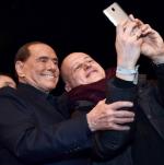 Silvio Berlusconi, lider Forza Italia, pozuje do seflie na spotkaniu wyborczym w Mediolanie 