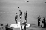 Meksyk, 16 października 1968, olimpijskie podium po biegu na 200 m. Od lewej: Peter Norman (Australia – srebro),  Tommie Smith (USA – złoto) i John Carlos (USA – brąz)