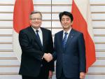 <Wizyta prezydenta Bronisława Komoro- wskiego  w Japonii  i podpisanie umowy o wprowadze- niu programu „Zwiedzaj  i pracuj”  w 2015 r.  Na zdjęciu prezydent  z premierem Shinzō Abe 