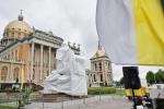 Zasłonięty pomnik ks. Makulskiego  klęczącego u stóp papieża, Licheń 