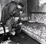 Śledczy oglądają sofę z saloniku w bunkrze Hitlera. Na oparciu widać krwawe zacieki 