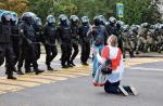 Klęcząca kobieta powstrzymuje OMON. W niedzielę w Mińsku protestowało ponad 100 tys. ludzi  