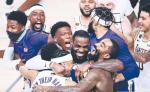 Gwiazdor Los Angeles Lakers LeBron James (w środku) świętuje z kolegami zwycięstwo w finale NBA