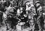 Żołnierze brytyjscy dzielą się zapasami czekolady i papierosów. Zdjęcie wykonane w okolicach Arnhem we wrześniu 1944 r. 