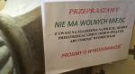 W przedsionku kościoła Świętej Trójcy w Czudcu kościelny liczy wchodzące dusze, by w stosownym momencie wywiesić tabliczkę: „Brak wolnych miejsc. Proszę nie wchodzić”. Wcześniej wisiała inna (na zdjęciu). Pojawiła się po szeregu doniesień  o przekraczaniu pandemicznego limitu osób  w świątyni. Policja interweniowała w tej sprawie dziesięciokrotnie przez pół roku