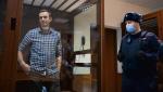 Aleksiej Nawalny w szklanej celi podczas  rozprawy w sądzie rejonowym w Moskwie,  20 lutego 2021 r. Odpowiadał za domniemane obrażenie weteranów Wielkiej Wojny Ojczyźnianej. 94-letni były żołnierz poczuł się dotknięty słowami  o „skorumpowanych lokajach”, mimo, że  nie były skierowane wprost do niego.  Tydzień po wykonaniu tego zdjęcia opozycjonista  został przewieziony do kolonii karnej,  gdzie przebywa do dziś 