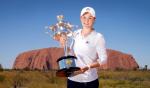 Ashleigh Barty z nagrodą za zwycięstwo w Australian Open 2022 na tle Uluru – świętej góry Aborygenów