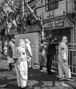 Policja chińska w kombinezonach na ulicach Szanghaju, 15 marca