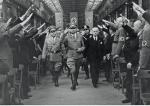 Rudolf Hess (w środku) w towarzystwie przywódcy Niemieckiego Frontu Pracy Roberta Leya (z lewej), kierownika zakładów Bohlena von Kruppa (z prawej) i prezesa włoskiego Związku Robotników Przemysłowych Capoferri (z tyłu) między szpalerem pracowników. Essen, maj 1940 r.