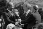 Prezydent Egiptu Anwar as-Sadat (od lewej) ściska dłonie prezydenta USA Jimmy’ego Cartera (w środku) i premiera Izraela Menachema Begina (z prawej) po podpisaniu izraelsko- -egipskiego traktatu pokojowego. Waszyngton, ogrody Białego Domu, 26 marca 1979 r.