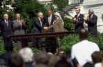 Icchak Rabin i Jasir Arafat w towarzystwie prezydenta USA, Billa Clintona, podają sobie ręce po podpisaniu porozumienia izraelsko-palestyńskiego. Ogród Różany Białego Domu, 13 września 1993 r.
