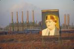 Pozłacany portret libijskiego przywódcy Muammara Kaddafiego (1942–2011) na tle rafinerii ropy naftowej Ras Lanuf w północnej Libii, marzec 2000 r.