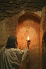 Artysta malarz Wojciech Chmiel studiuje wizerunek św. Damiana w świetle kaganka