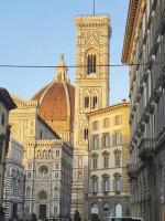 Skąpany w promieniach słońca fragment ogromnej katedry Santa Maria del Fiore z widoczną kopułą Brunelleschiego oraz dzwonnicą Giotta we Florencji