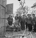 Premier Wielkiej Brytanii, sir Winston Churchill, siedzi na zniszczonym krześle w otoczeniu brytyjskich i radzieckich oficerów – przed wejściem do bunkra Hitlera. Berlin, 16 lipca 1945 r.
