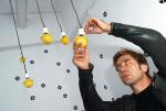 Tomasz Rygalik montuje osłonki na żarówki własnego projektu