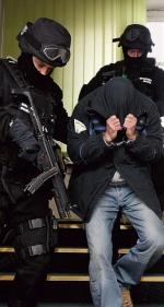 Żandarmi prowadzą jednego z podejrzanych w Wojskowym Sądzie Okręgowym w Poznaniu  