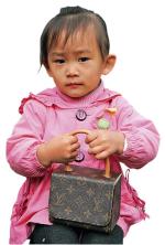 Szanghaj, dziewczynka z podróbką torby ekskluzywnej firmy Louis Vuitton