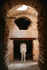 Jedna  z dwóch figur stoi oświetlona blisko wejścia do Cysterny