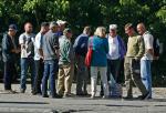 Kobieta z czerwoną torebką bada rynek. Chce się dowiedzieć, ile kosztuje docieplanie domu styropianem. Stawki zaczynają się od 35 złotych za metr kwadratowy 