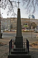 Niepozorna kolumna na pl. Starynkiewicza upamiętnia  30 tysięcy zmarłych w drugiej połowie XIX W., pochowanych  wokół dawnej siedziby Szpitala Dzieciątka Jezus 