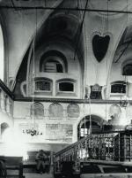 Wnętrze XVII-wiecznej synagogi w Szczebrzeszynie. U góry nad wejściem zakratowane okna babińca; poniżej wnęki oraz płaszczyzny ścian wypełnione tekstami modlitw. Fot. sprzed 1939 roku  